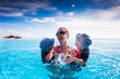 Happy family splashing in swimming pool on a tropical resort