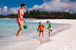 Mother and twin boys playing on the beach