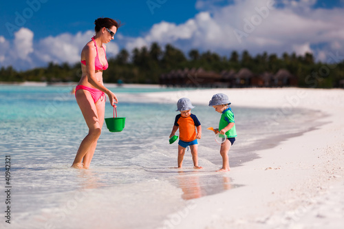 Photo: Mother and twin boys playing on the beach Mother and twin boys playing on the beach