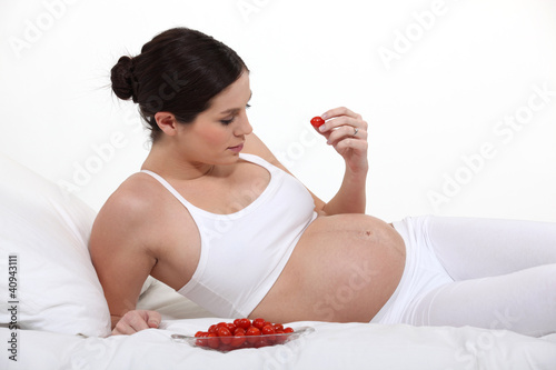 Photo: Pregnant woman eating tomatoes Pregnant woman eating tomatoes