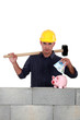 Construction worker putting money into a piggy bank