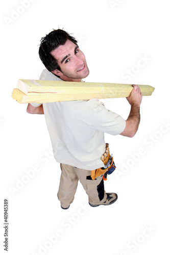 Foto: High-angle shot of a handyman carrying wooden planks High-angle shot of a handyman carrying wooden planks