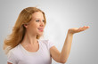 Beautiful girl gives a presentation, holding something in hands