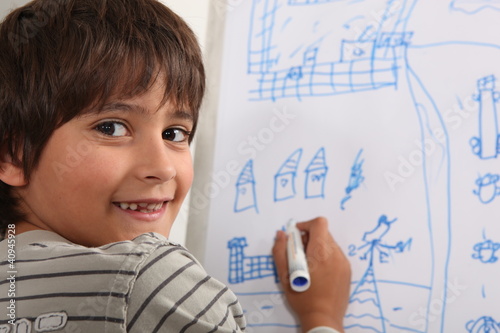 Photo: Boy drawing on blackboard Boy drawing on blackboard