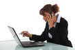 Businesswoman using a laptop and phone