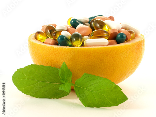 Photo: Concept shot with vitamin pills in a grapefruit Concept shot with vitamin pills in a grapefruit