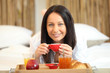 Woman enjoying breakfast in bed Woman enjoying breakfast in bed