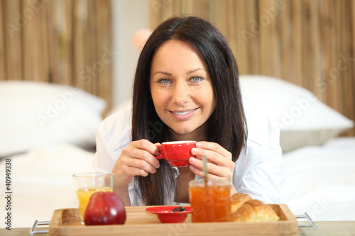 Photo: Woman enjoying breakfast in bed Woman enjoying breakfast in bed