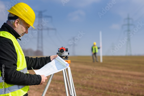 Photo: Geodesist measure land on construction site Geodesist measure land on construction site