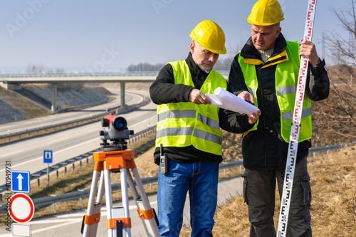 Photo: Geodesist read plans on construction site Geodesist read plans on construction site