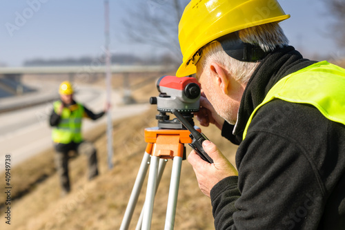 Photo: Geodesist measure land with tacheometer highway Geodesist measure land with tacheometer highway