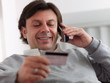 adult man shopping from home with telephone and credit card