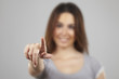 Portrait of a beautiful young woman pointing at you, isolated