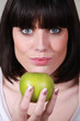 Brunette holding green apple Brunette holding green apple