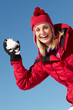 Woman About To Throw Snowball Wearing Warm Clothes On Ski Holida