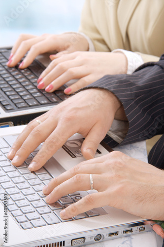 Photo: Hands of business people on notebook keyboard Hands of business people on notebook keyboard