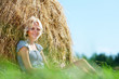 girl next to a stack of hay girl next to a stack of hay