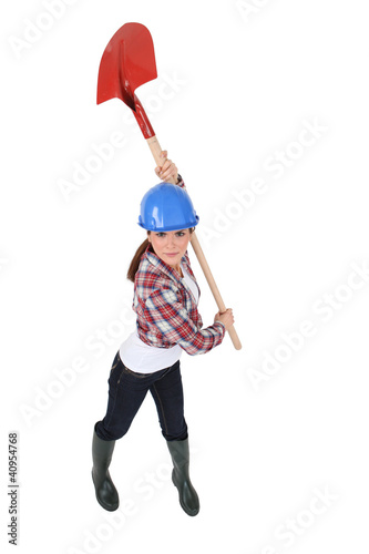 Foto: Woman holding spade over head Woman holding spade over head
