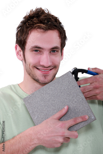 Photo: Man with a tile cutter Man with a tile cutter