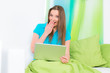 junge frau sitzt lachend am laptop