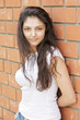 Young brunette at brick wall