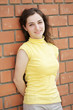 Smiling brunette at brick wall