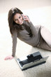 Smiling woman with mobile phone and laptop