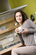smiling woman having breakfast at home