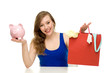 Woman with piggybank and shopping bags