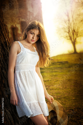 Photo: beautiful girl with hat and white dress in the garden beautiful girl with hat and white dress in the garden