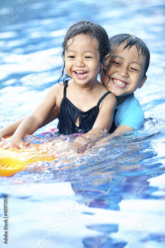 Photo: Sibling having fun at swimming pool Sibling having fun at swimming pool