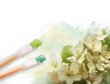 Artist brushes with a half finshed painted floral canvas