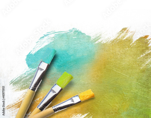 Photo: Artist brushes with a half finished painted canvas Artist brushes with a half finished painted canvas