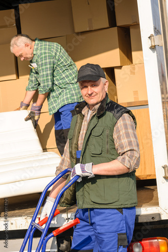 Foto: Mover two man loading furniture on truck Mover two man loading furniture on truck