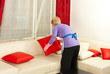 Photo: Woman arrange pillows on sofa Woman arrange pillows on sofa