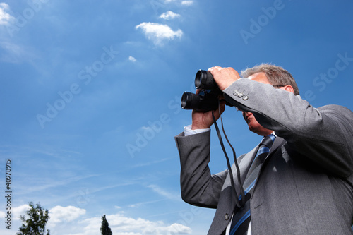 Foto: Mann mit Fernglas hält Ausschau Mann mit Fernglas hält Ausschau