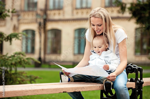 Photo: Young woman and her son looking at a map outdoors Young woman and her son looking at a map outdoors