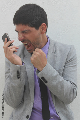 Photo: An angry businessman is shouting at his mobile phone An angry businessman is shouting at his mobile phone