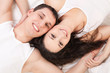 Young happy couple lying in the white bed