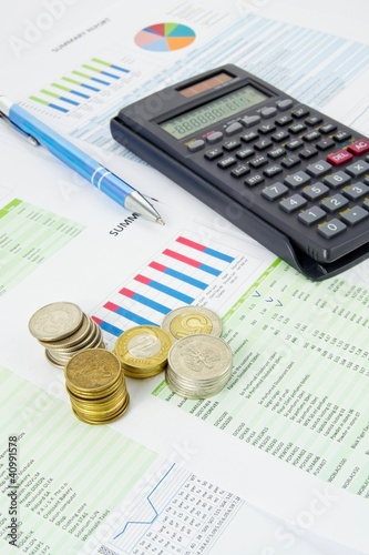 Photo: Calculator, pen, coins on a colorful business background Calculator, pen, coins on a colorful business background