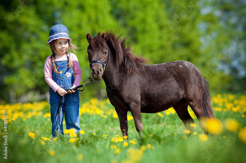 Photo: Child and small horse in the field at spring. Child and small horse in the field at spring.