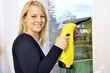 Junge Frau putzt Fenster