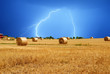 lightning over bales of hay in the field lightning over bales of hay in the field