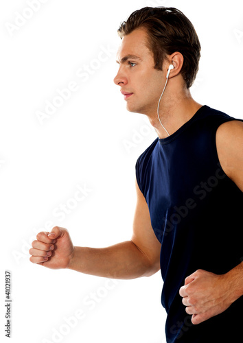 Photo: Fit athlete enjoying music in a jogging posture Fit athlete enjoying music in a jogging posture