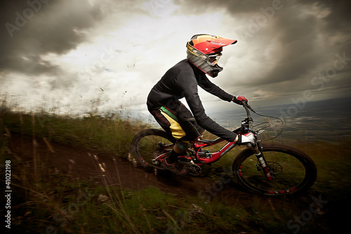Photo: Young man riding a mountain bike downhill style Young man riding a mountain bike downhill style