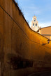 Church bell tower rises above colourfull wall in old Rome