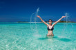 Beautiful woman jumps out of the sea leaving a splash