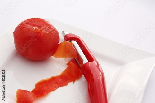 Photo: Une tomate et son éplucheur Une tomate et son éplucheur