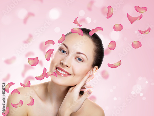 Foto: Young woman with flowers on background Young woman with flowers on background