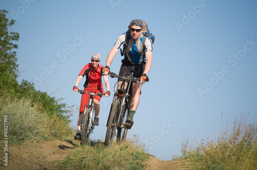 Photo: two cyclists biking two cyclists biking